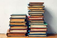 Image of two piles of books on a wooden board